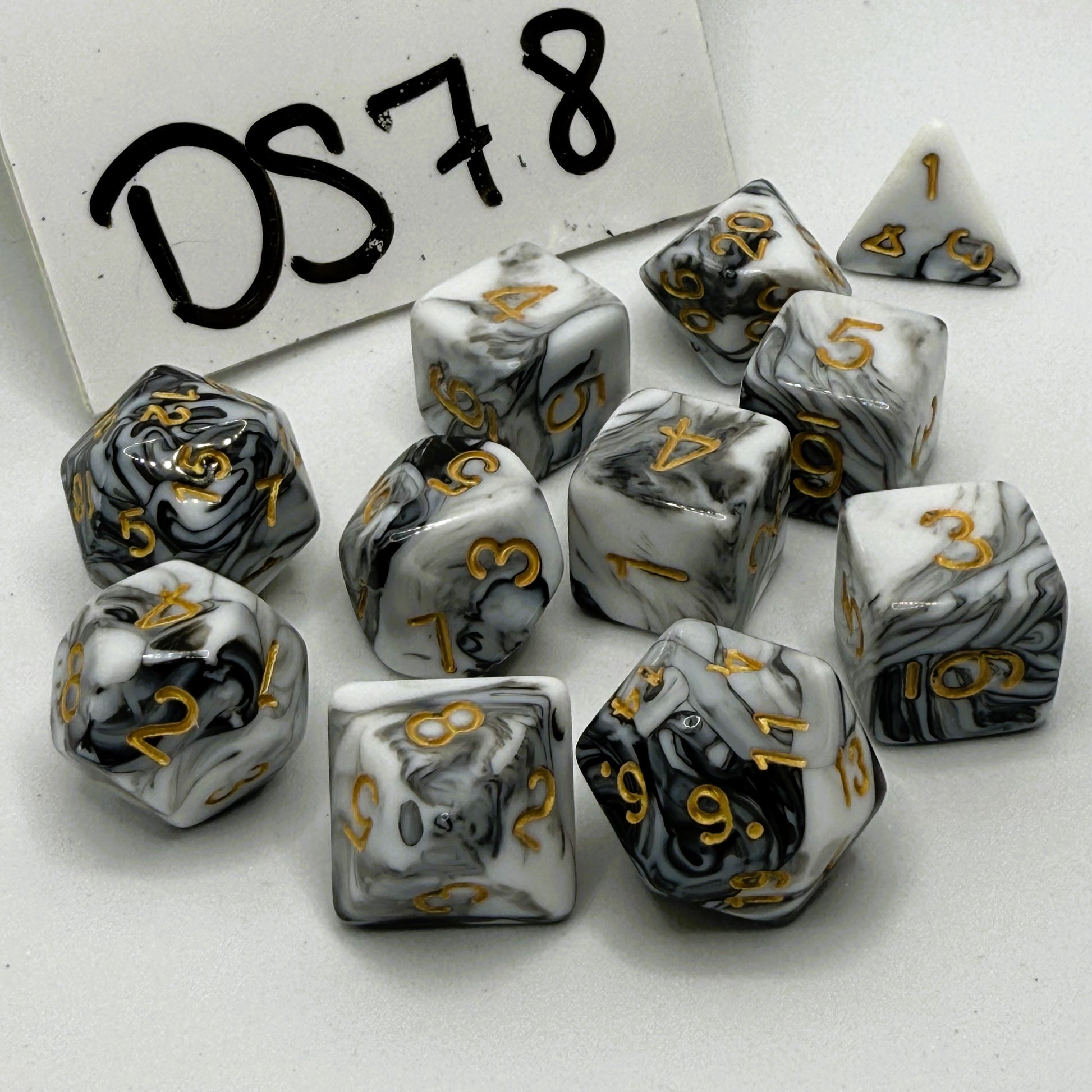 Set of black and white marbled dice with gold numbers on a white background, labeled 'DS78'.