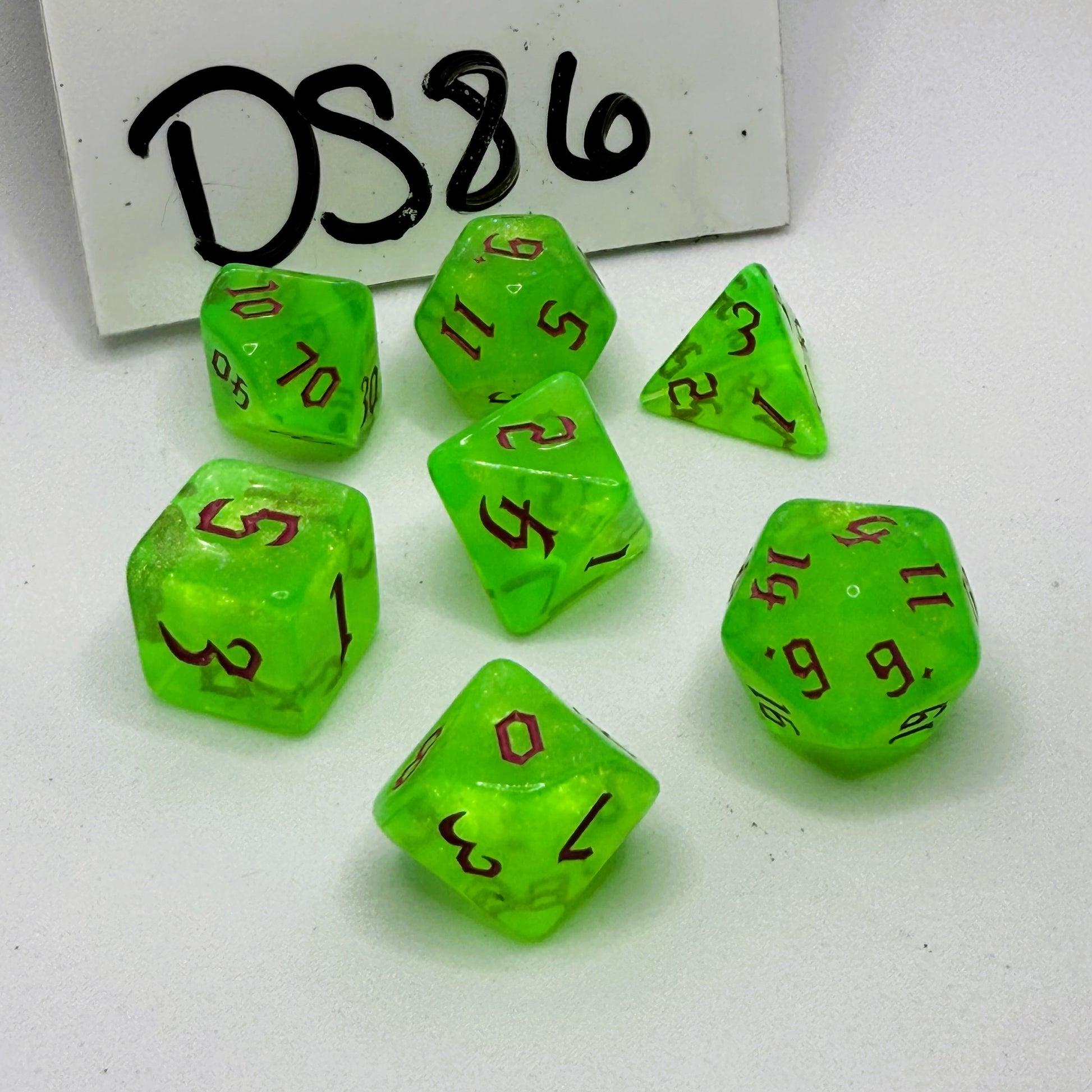 Set of green dice with brown numbers on a white background, with 'DS86' written above.