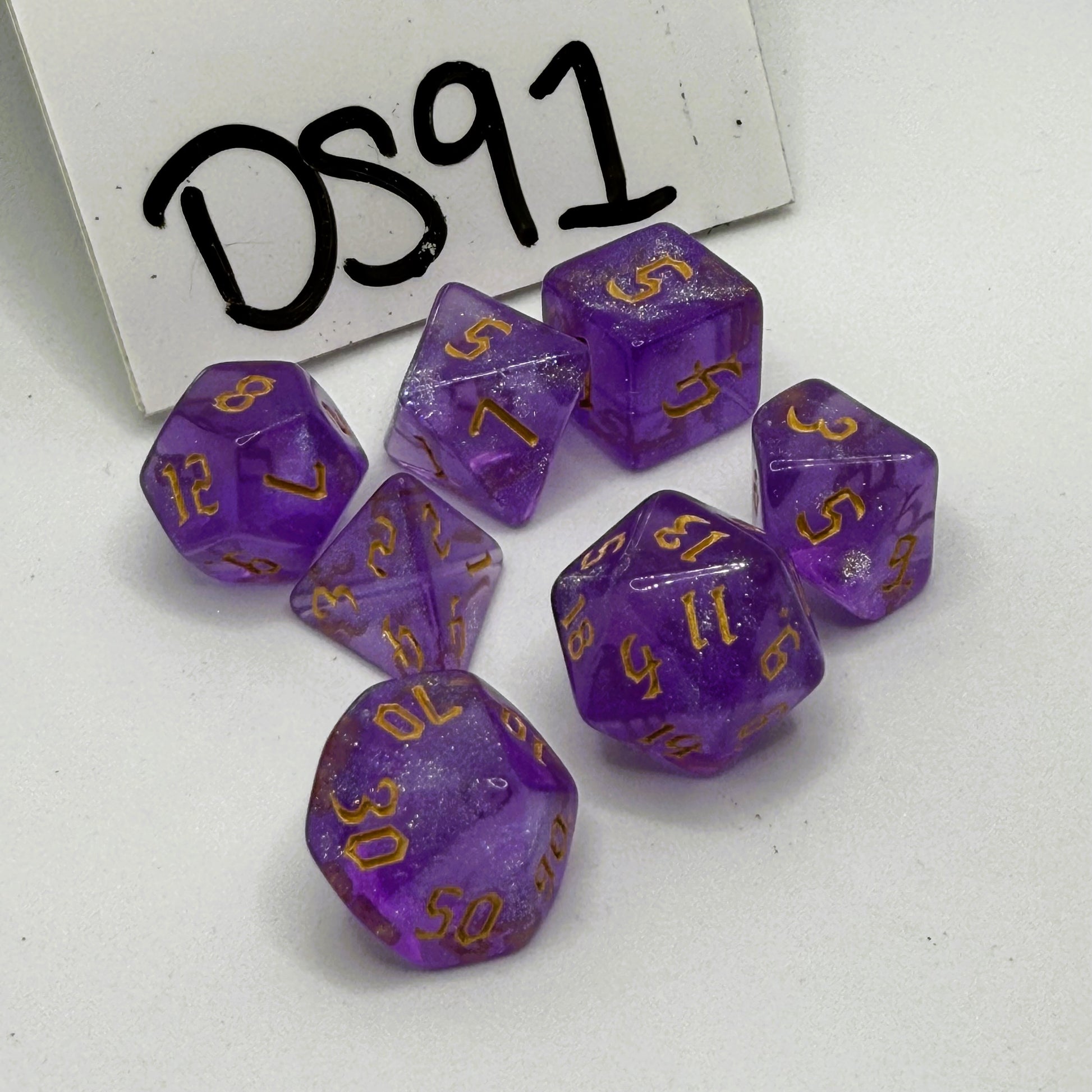 Purple dice set with gold numbers on a white background, labeled 'DS91'.