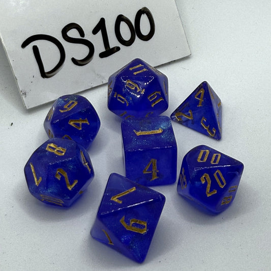 Photo of a set of 7 cobalt blue polyhedral dice with gold numbers.