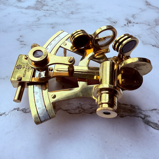 Brass sextant on a marble surface