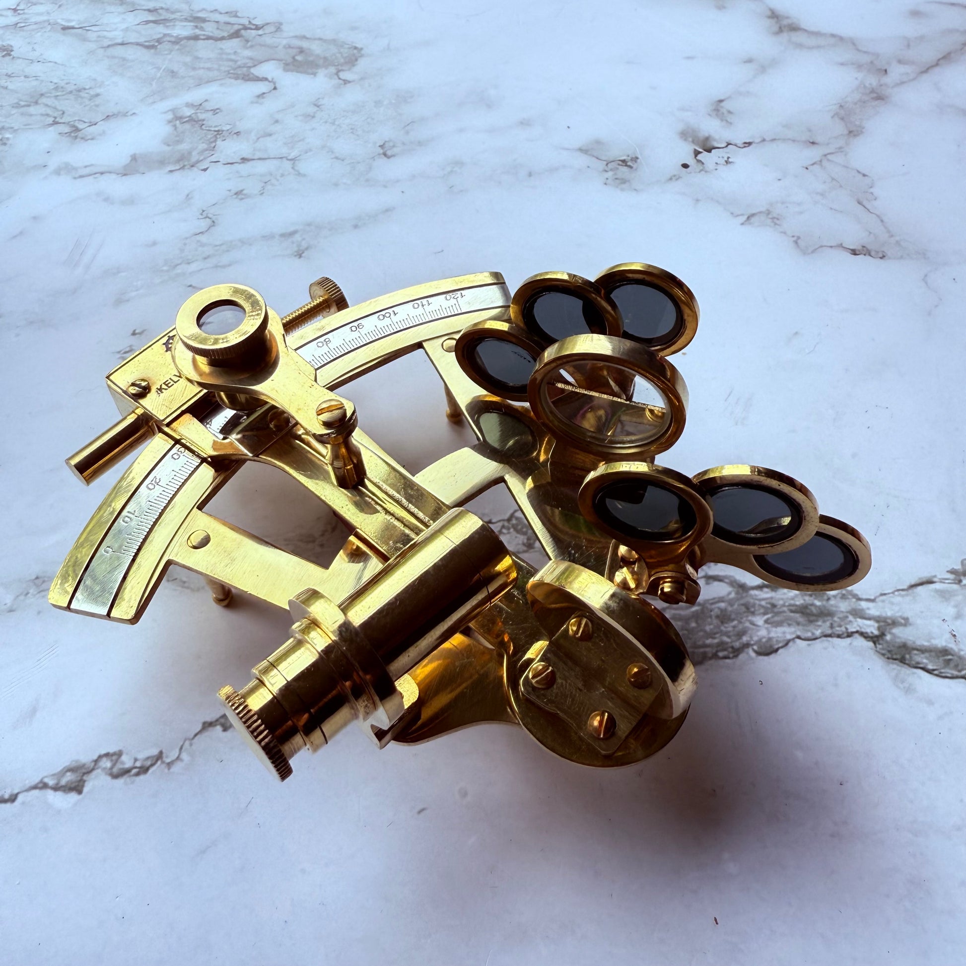 Brass sextant on a marble surface