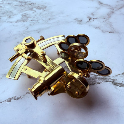 Brass sextant on a marble surface