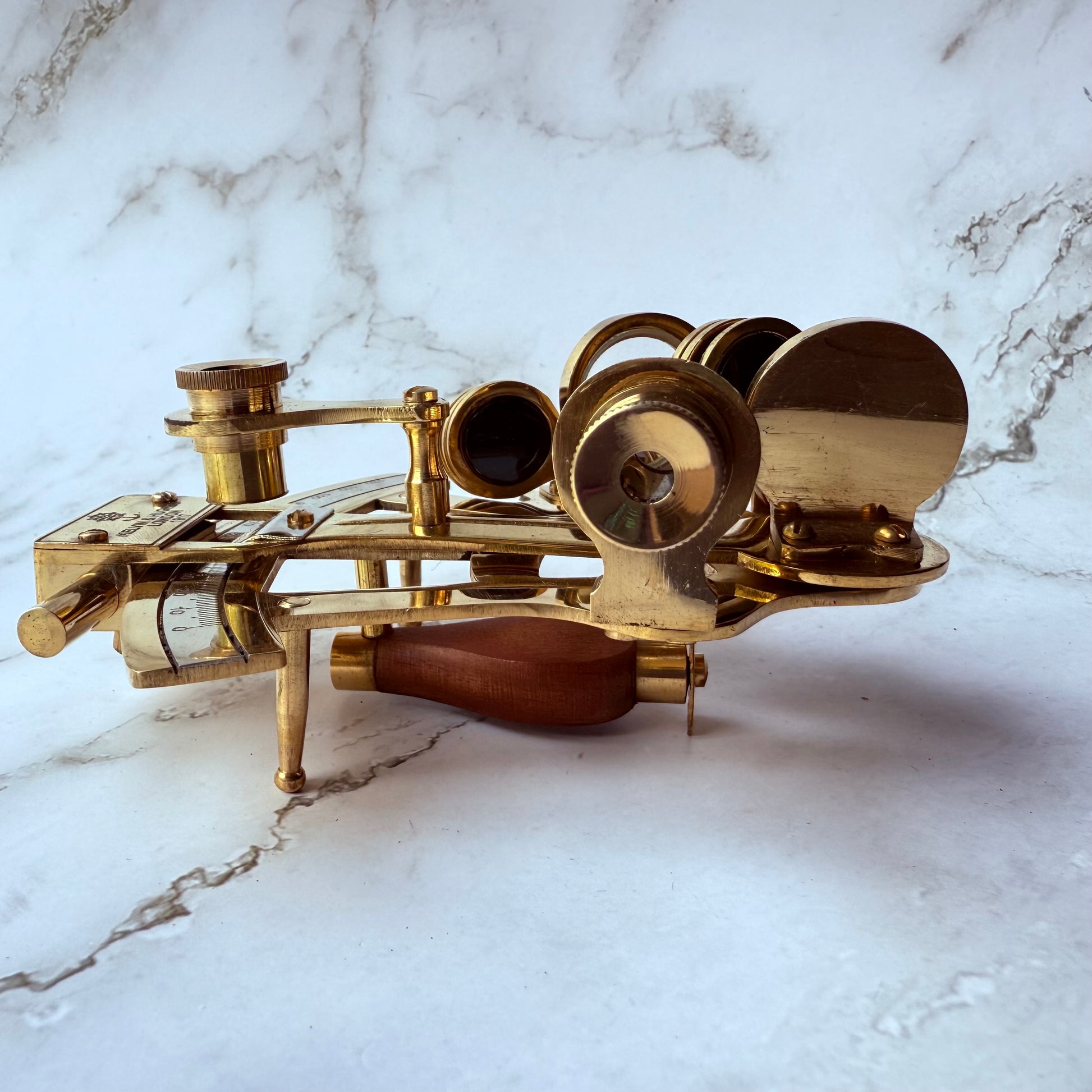 Brass sextant on a marble surface