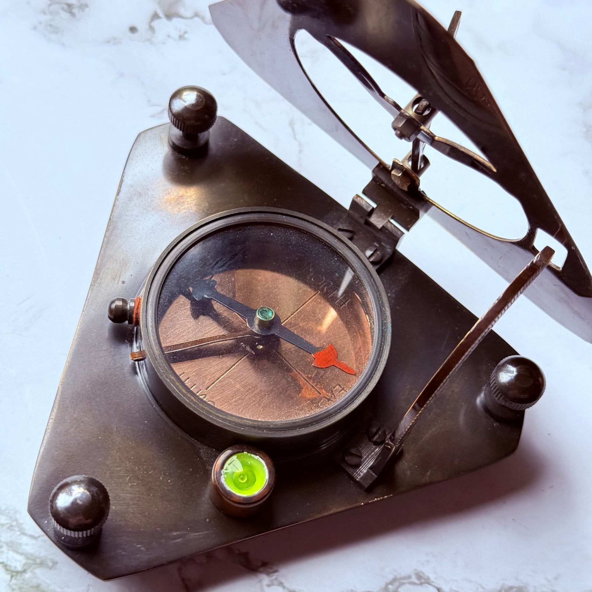 Vintage-style brass compass sundial on a marble surface