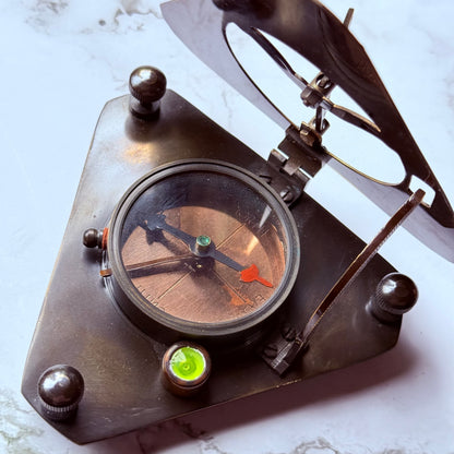 Vintage-style brass compass sundial on a marble surface