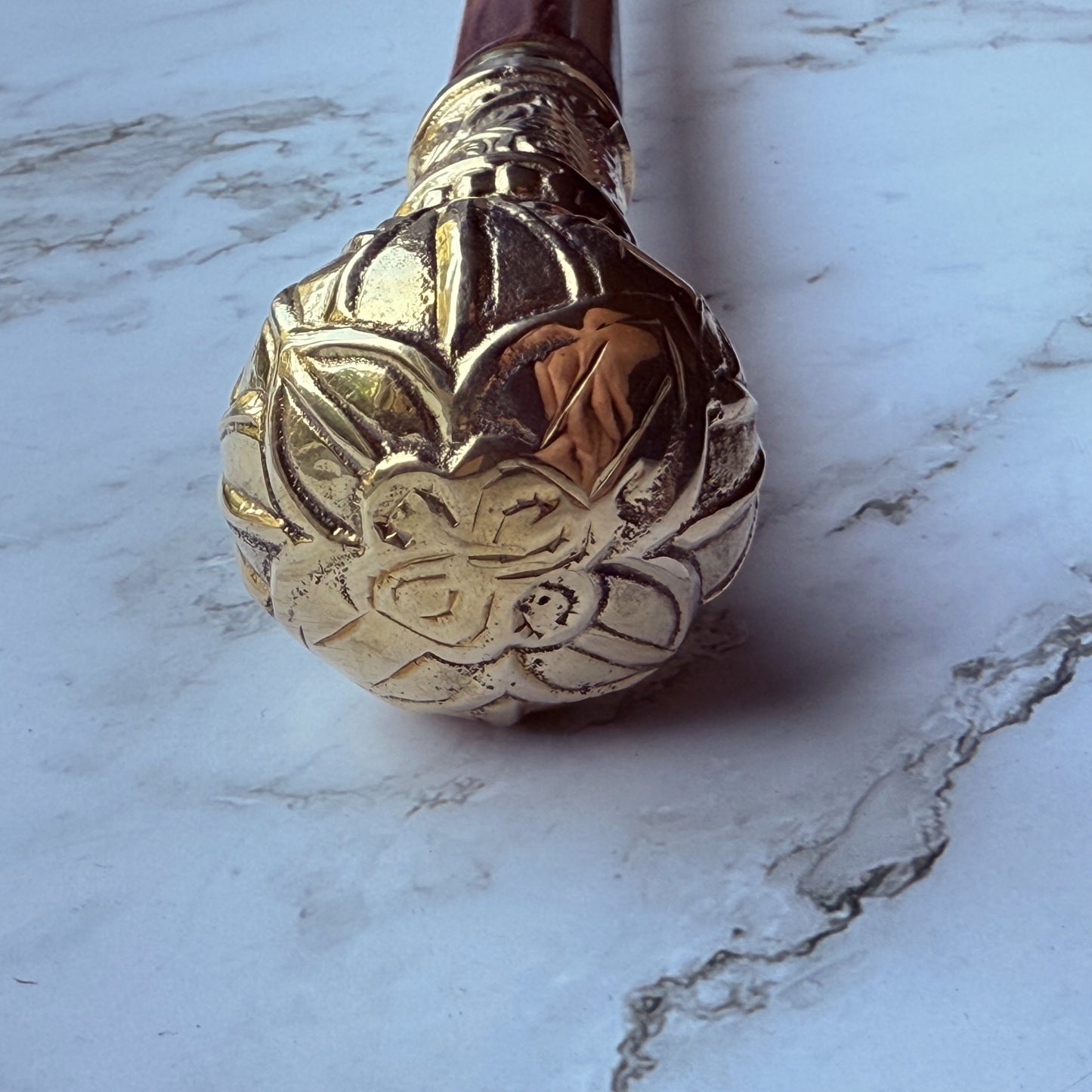 Decorative brass cane handle with a floral design