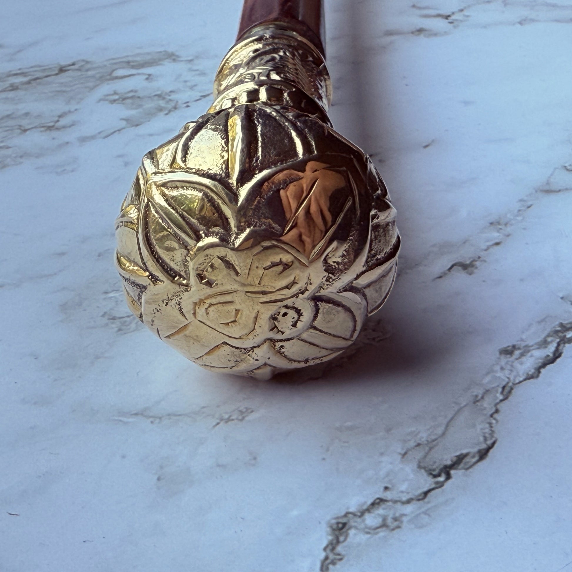 Decorative brass cane handle with a floral design