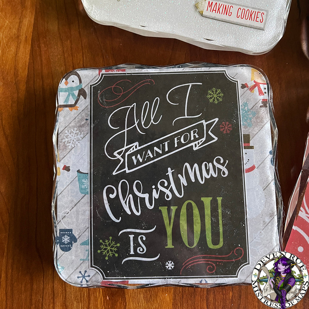 A close up of a resin coaster with winter illustrations and the words "All I want for Christmas is YOU".