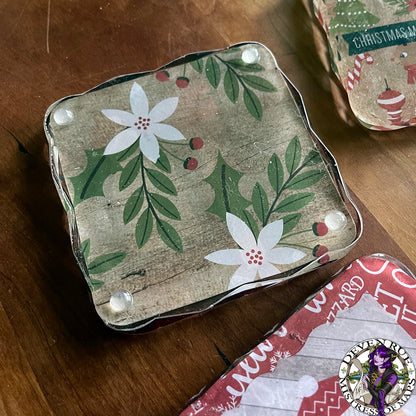 A resin coaster with winter flower and berry illustrations on it.