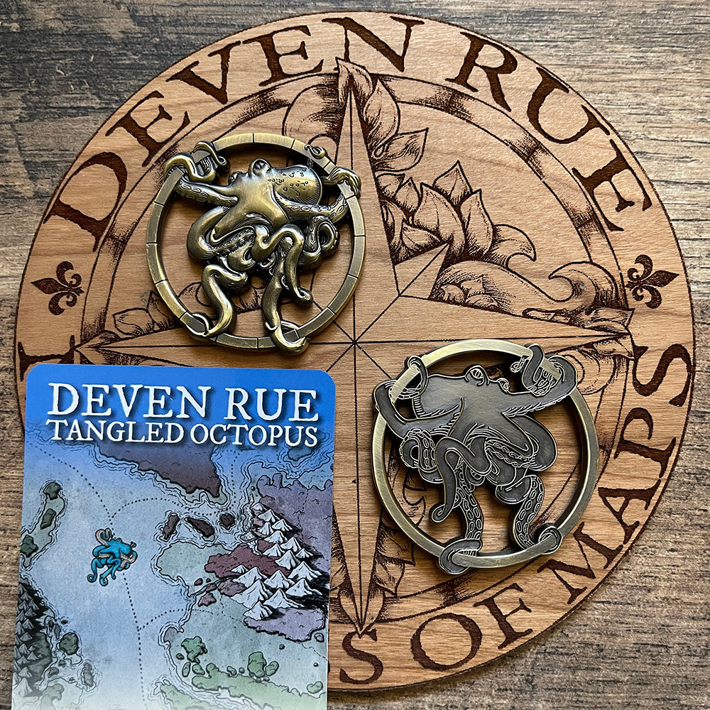Two Tangled Octopus map weights on the wooden Deven Rue logo to show front and back.