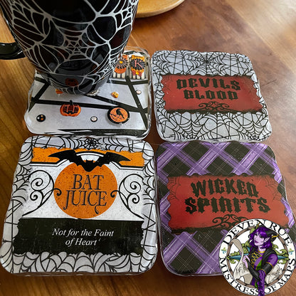 A set of four resin coasters with Halloween themed decorative paper inclusions and a mug for scale.