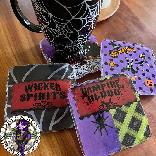 A set of four resin coasters with Halloween themed decorations on a table with a mug.