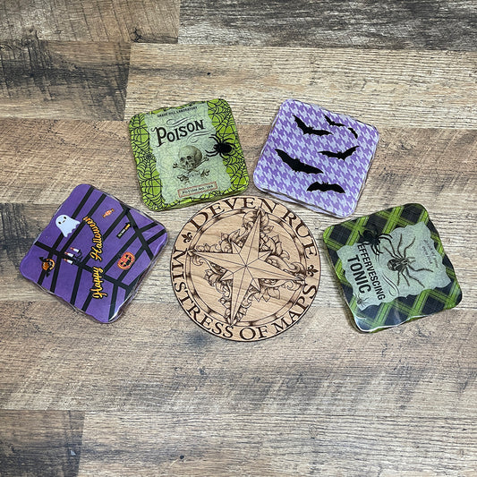 A set of four Halloween themed square resin coasters around the wooden Deven Rue logo.