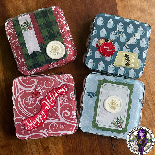 A set of four coasters with winter illustrations like snowflakes, florals, white wax seals with golden gilded snowflakes, and mugs with whipped cream.