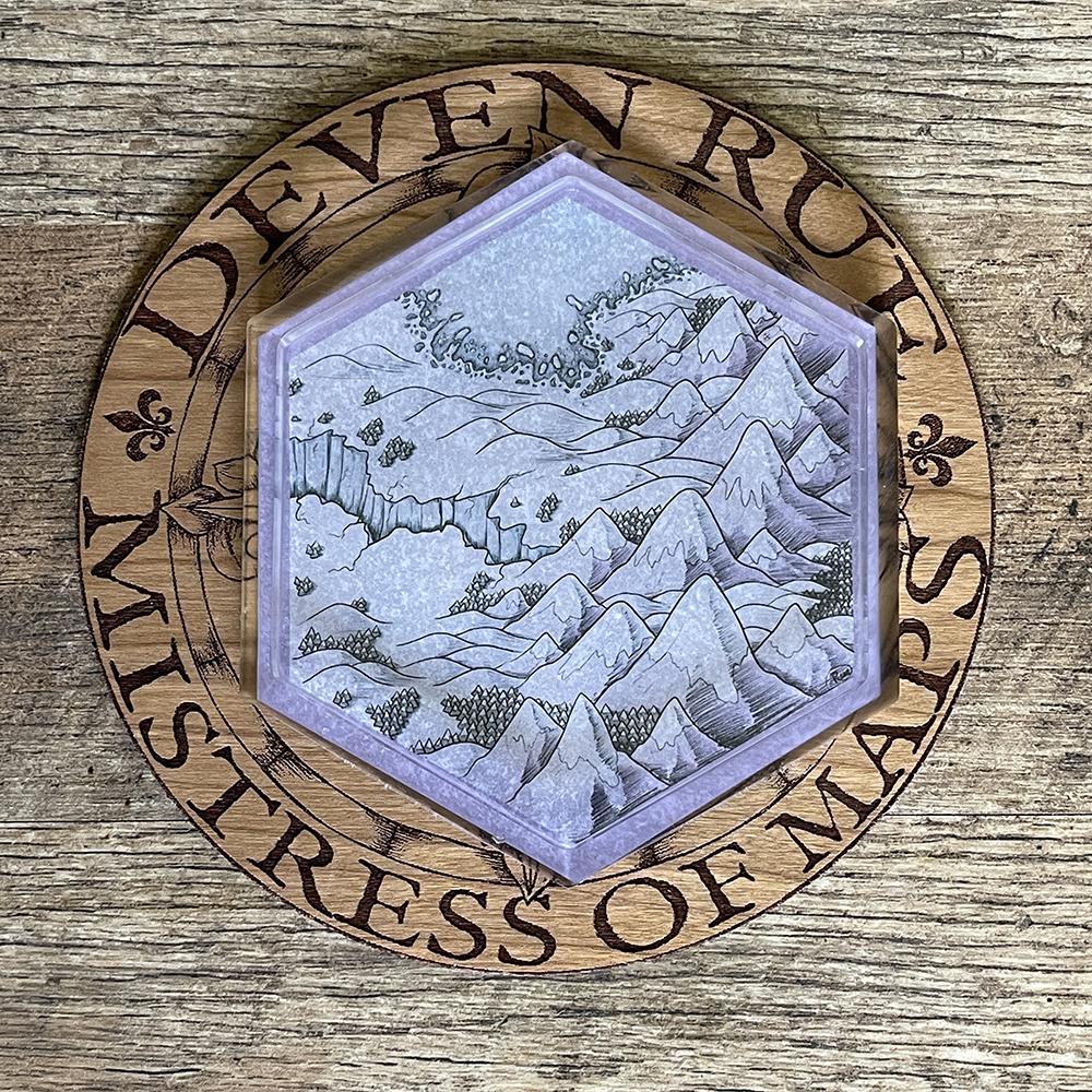 The Winter's Edge Hex Map coaster on the wooden Deven Rue logo.