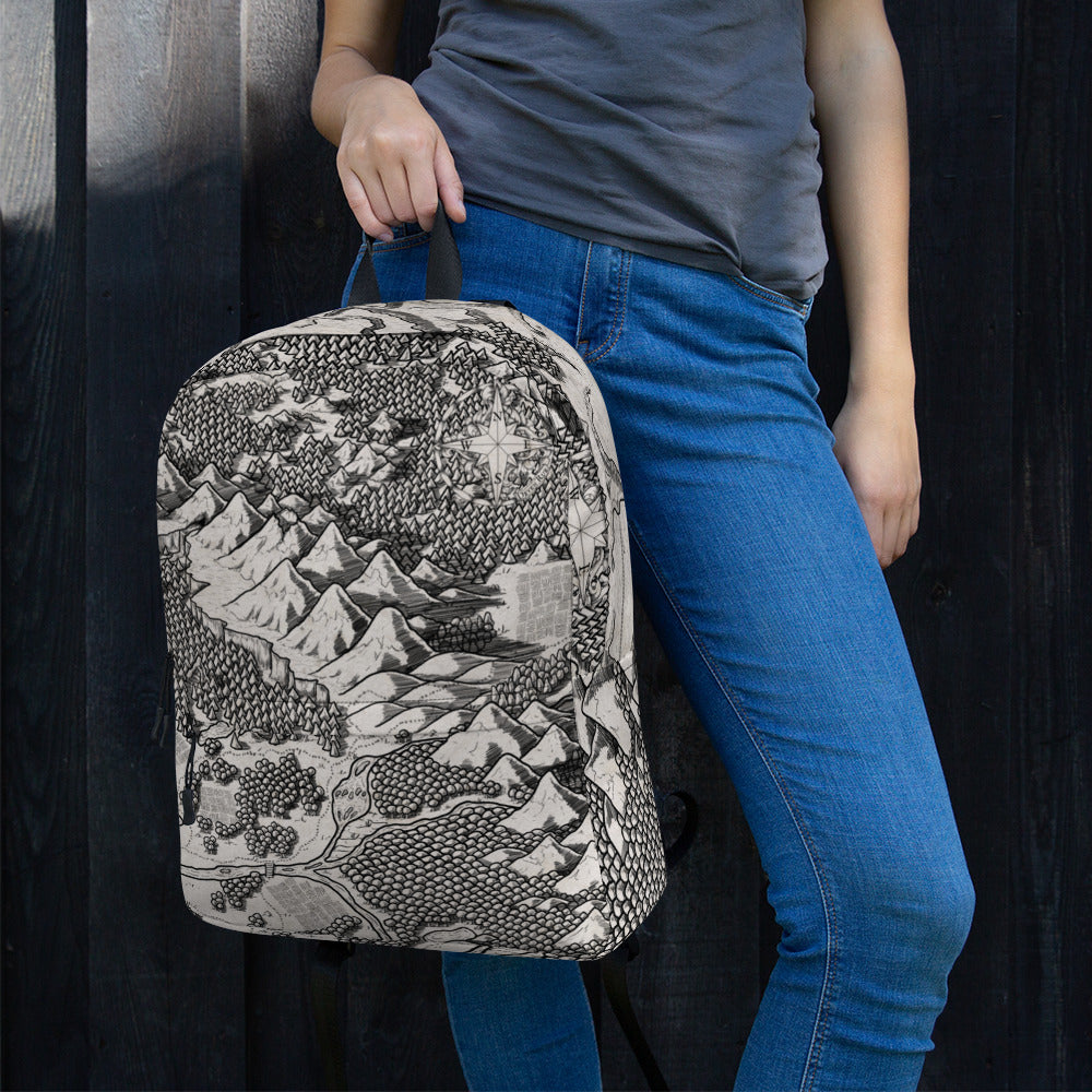 A model holds a backpack with the Arriving at Port map by Deven Rue printed on it.