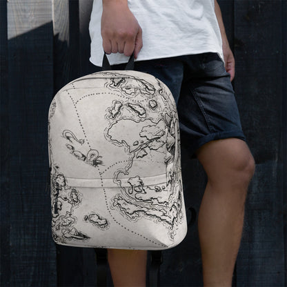 A model holds a backpack with the There Be Monsters map by Deven Rue printed on it by the top loop.