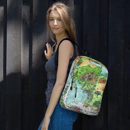 A model wears a backpack with The Queen's Treasure map by Deven Rue printed on it slung over one shoulder.