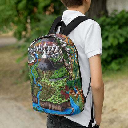 Right side view: A model wears a backpack with The Steppes of Augrudeen map by Deven Rue printed on it.