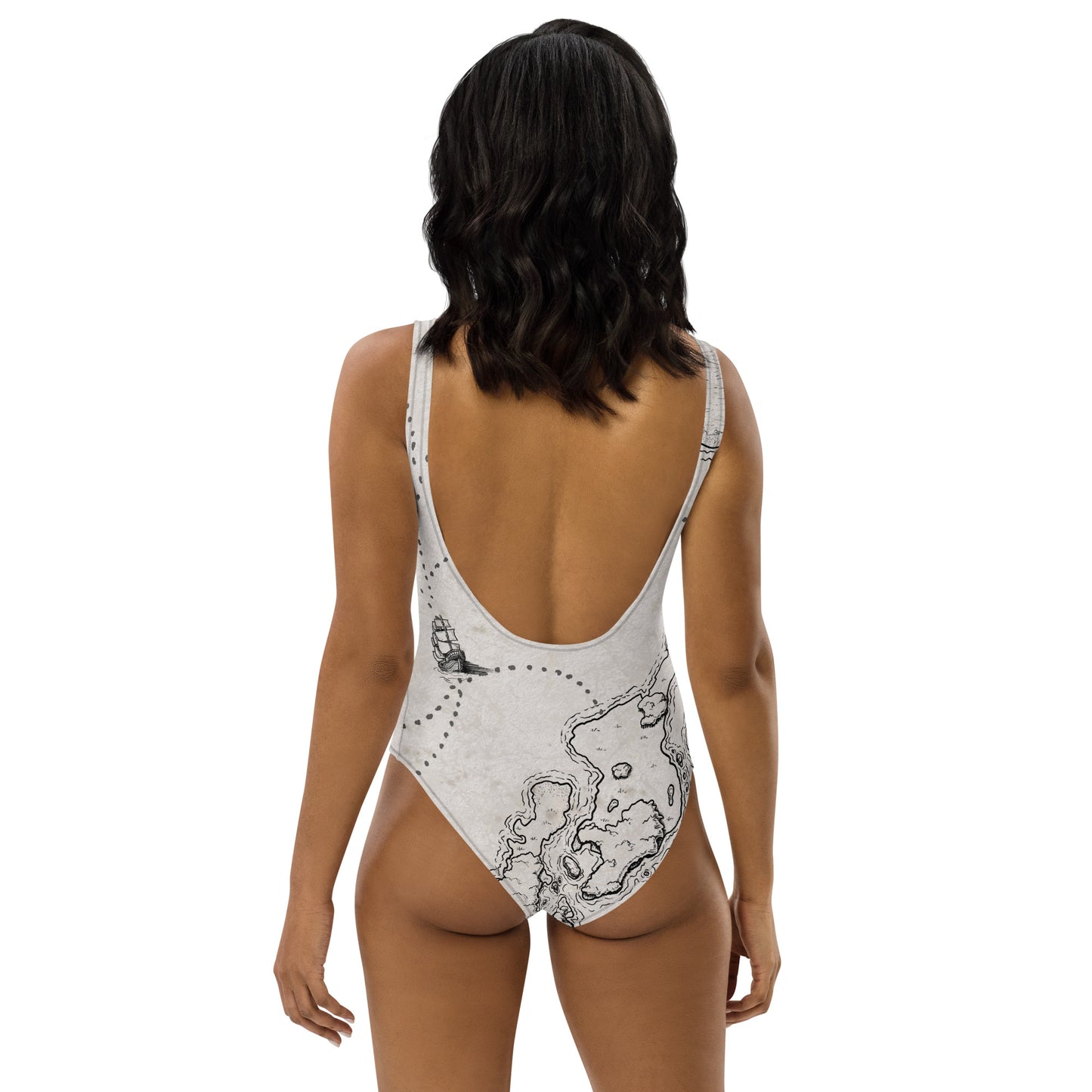 A model wears the Sailing into the Unknown one piece swimsuit by Deven Rue, back view.