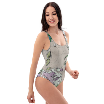 A model wears the Ortheiad map one piece swimsuit by Deven Rue, right view.