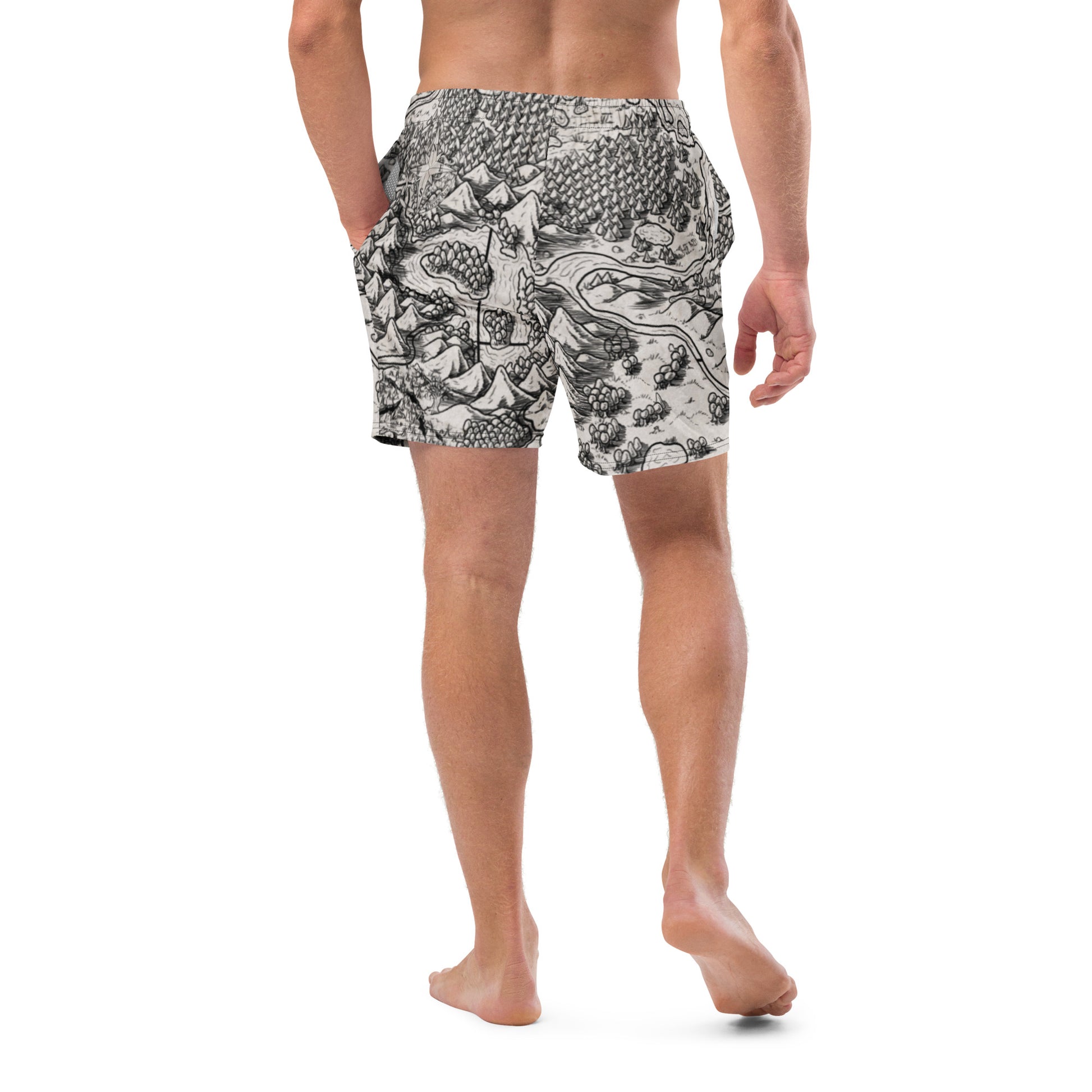 A model wears the Unexpected map swim trunks by Deven Rue, back view.