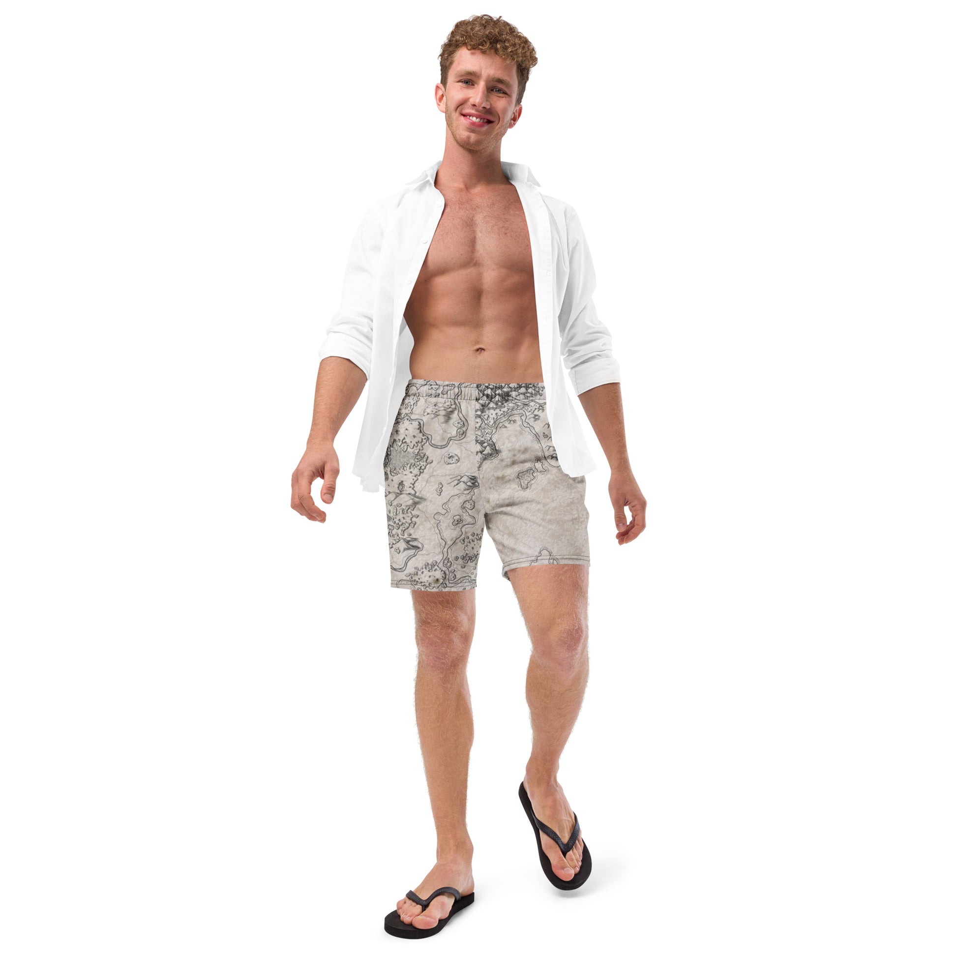 A model wears the Wallerfen swim trunks by Deven Rue with an open button up shirt and flip flops.