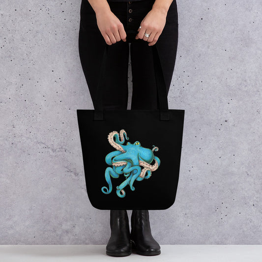 A black tote bag with the blue octopus illustration by Deven Rue.