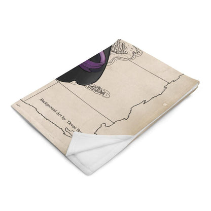 A minky blanket printed with Rue the Cartographer, a purple tiefling by Deven Rue shown over a parchment map sits folded up.