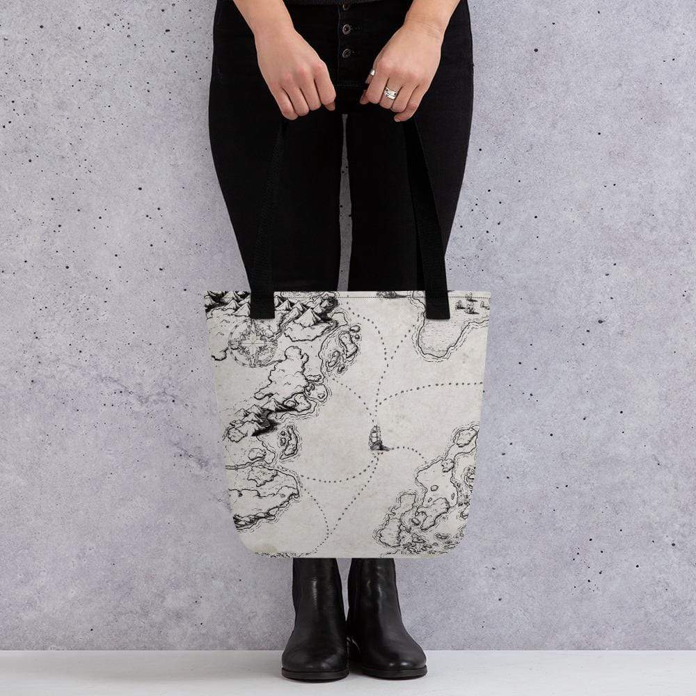 A model holds a tote bag featuring a black and white map by Deven Rue showing sailing routes between land masses.