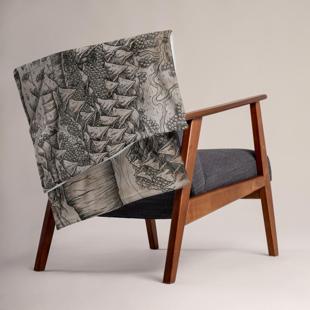 The Steppes of Augrudeen parchment map by Deven Rue is printed on a minky blanket, folded up on the back of a chair.