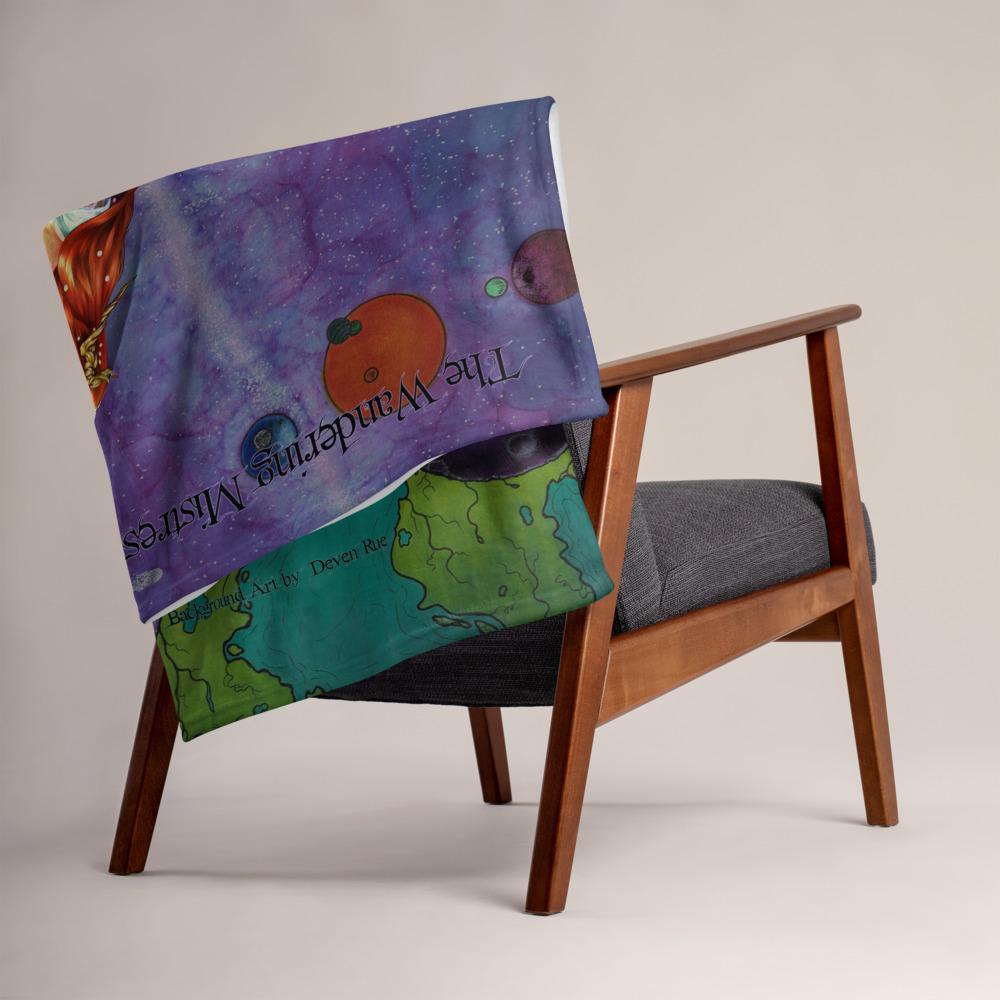 The Wandering Mistress throw blanket by Deven Rue is draped over a chair.