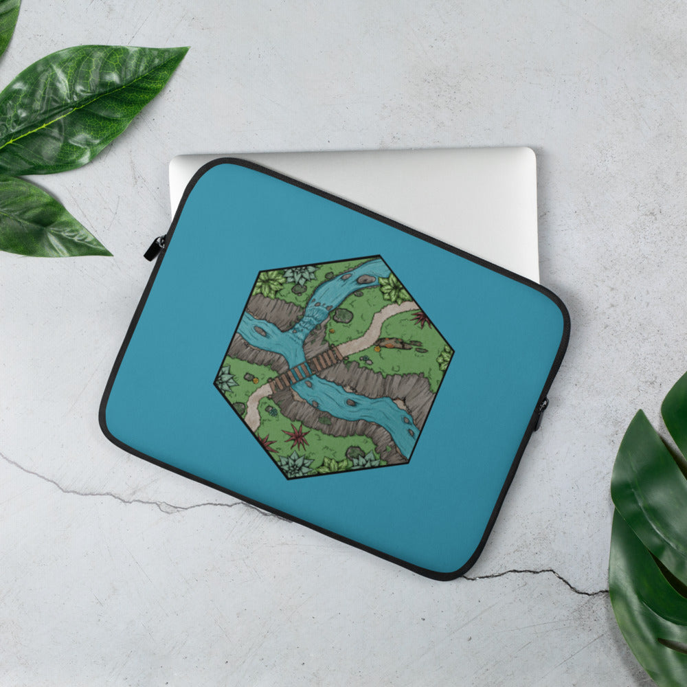 A blue laptop case with a hexagonal portion of an illustrated map showing a river crossing.