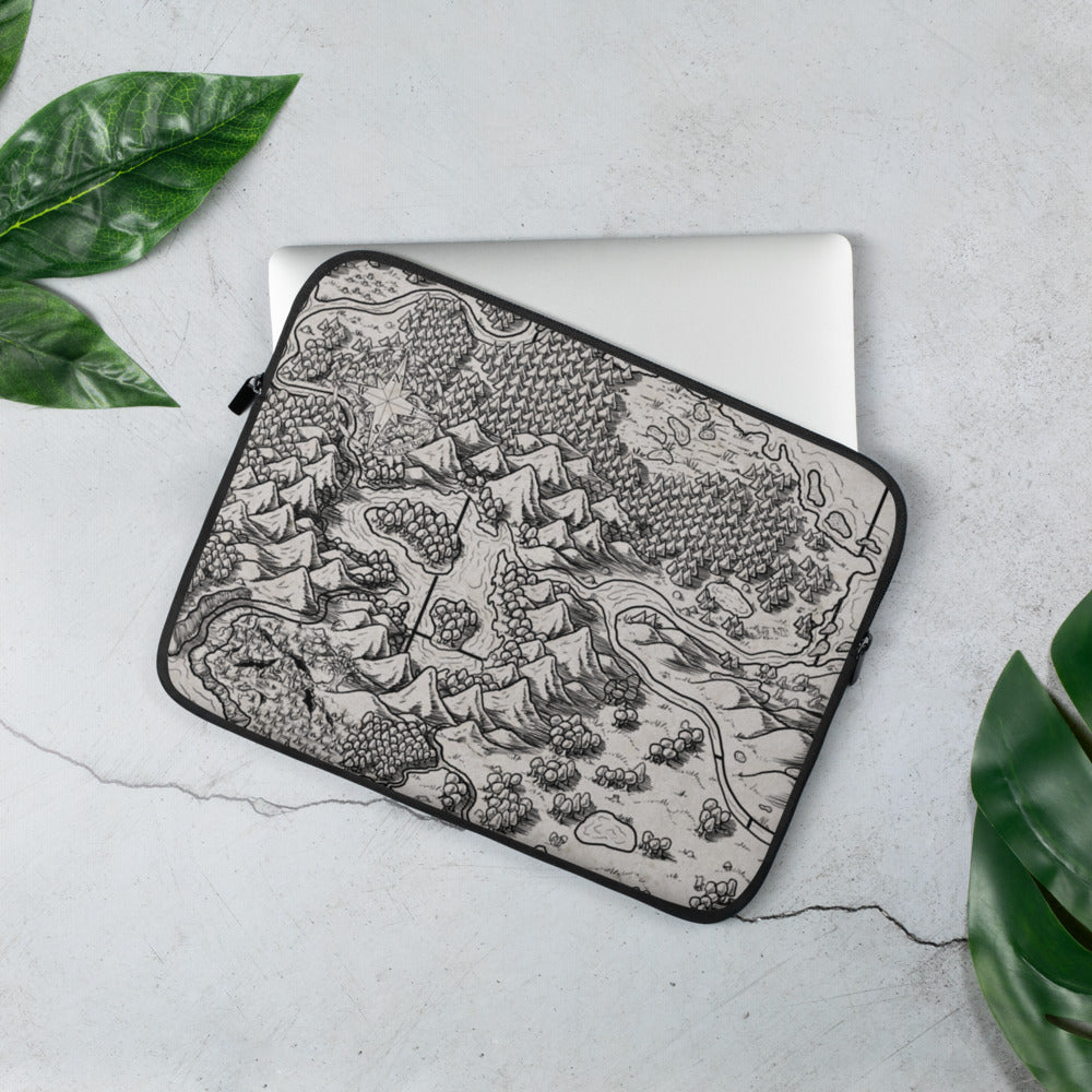 A laptop sleeve with a black and white map of a mountain range enclosing a water feature with islands. Greenery is around for scale.