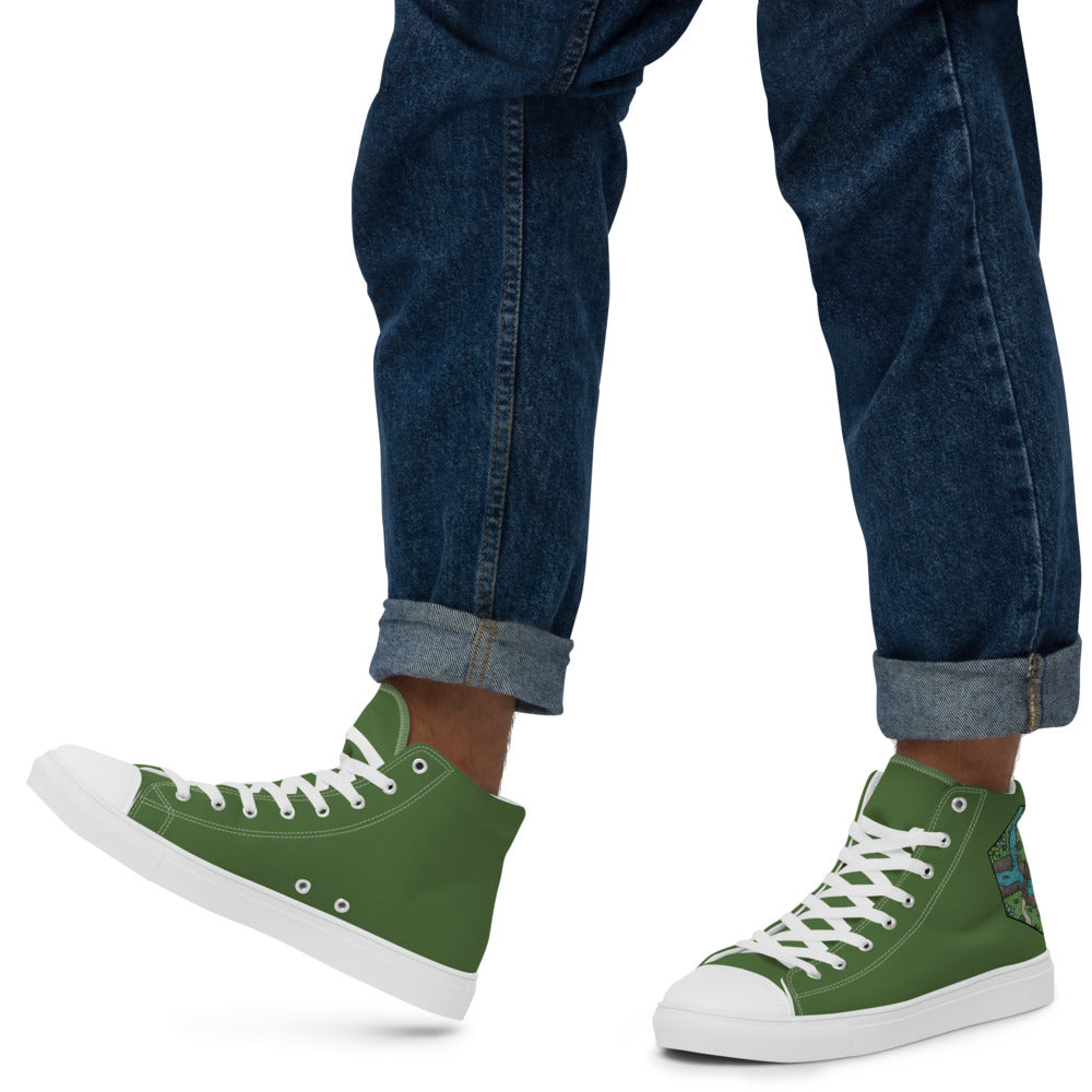 A model wears green high top shoes with the Perilous Crossing hex map illustration by Deven Rue on the heel with rolled up jeans.