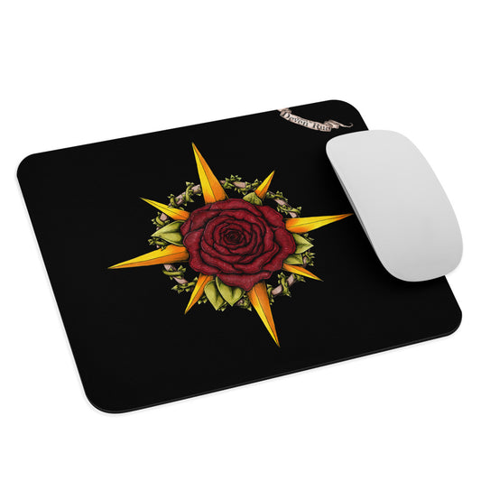 A black mousepad with the Druid Compass Rose illustration by Deven Rue with a mouse for scale.