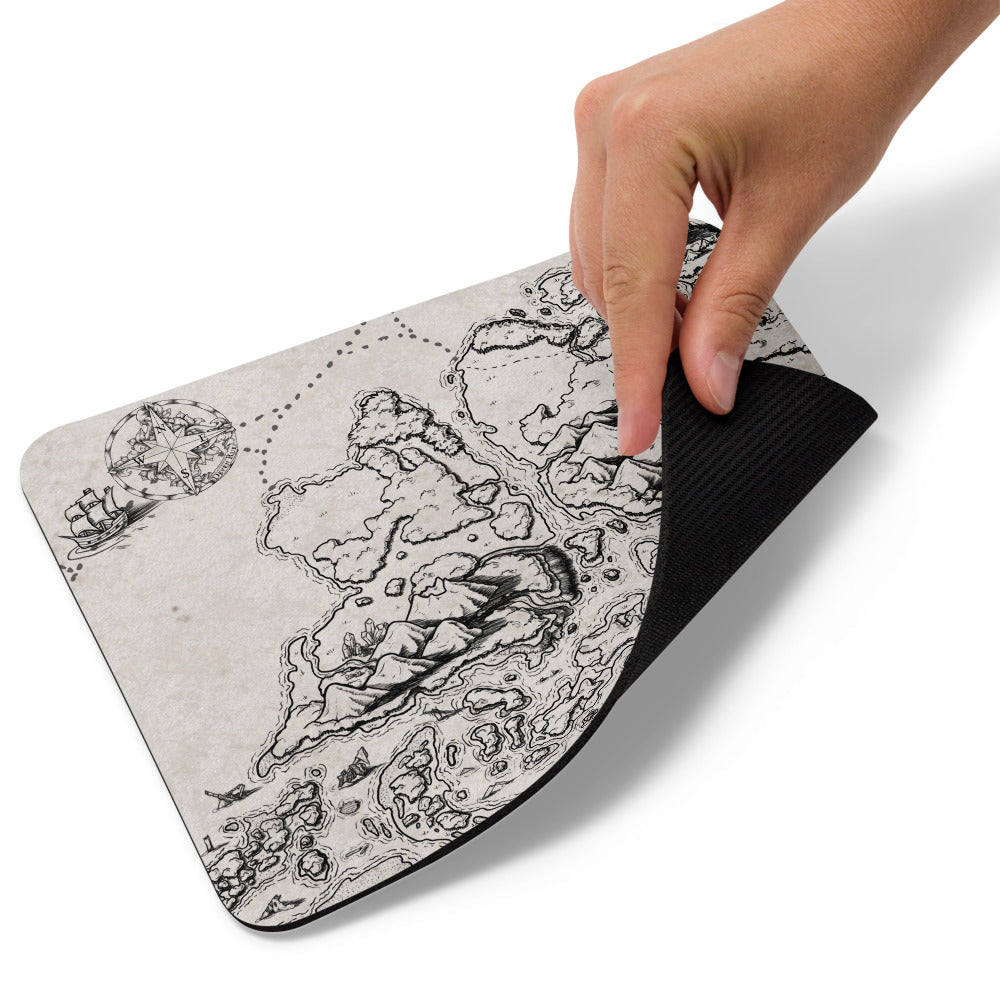A hand lifts up the corner of the Ship Graveyard map mousepad.