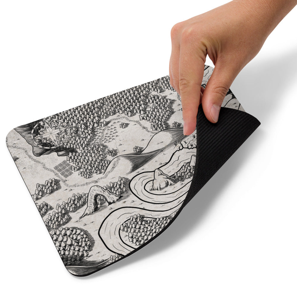 A hand picks up the corner of the Magical Arch mousepad.