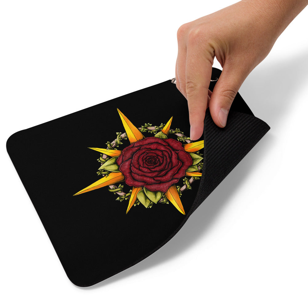 A hand lifts up the corner of the Druid Compass Rose mousepad.