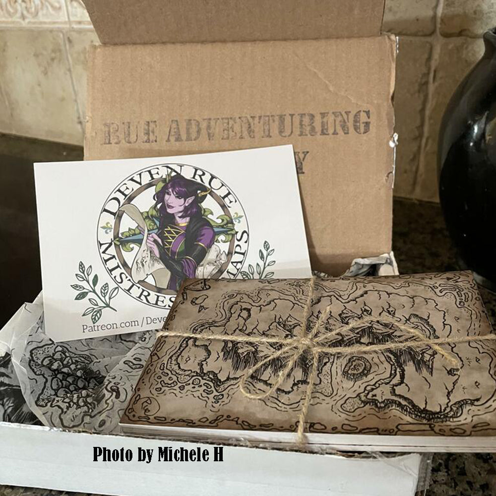 A photo by Michele H showing the postcards and Deven Rue's card being unboxed.