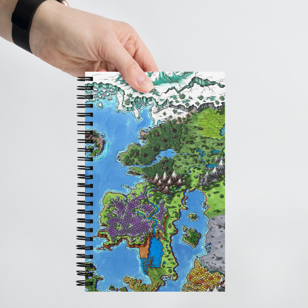A hand holds a spiral notebook with the Starfall map on the cover.