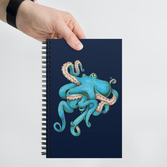 A hand holds the Tangled Octopus notebook.