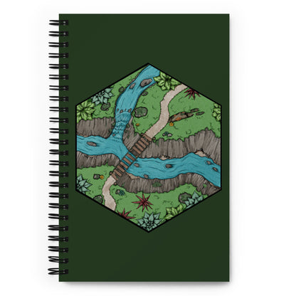 The Perilous Crossing hexagonal map is shown on the front of a forest green spiral notebook.
