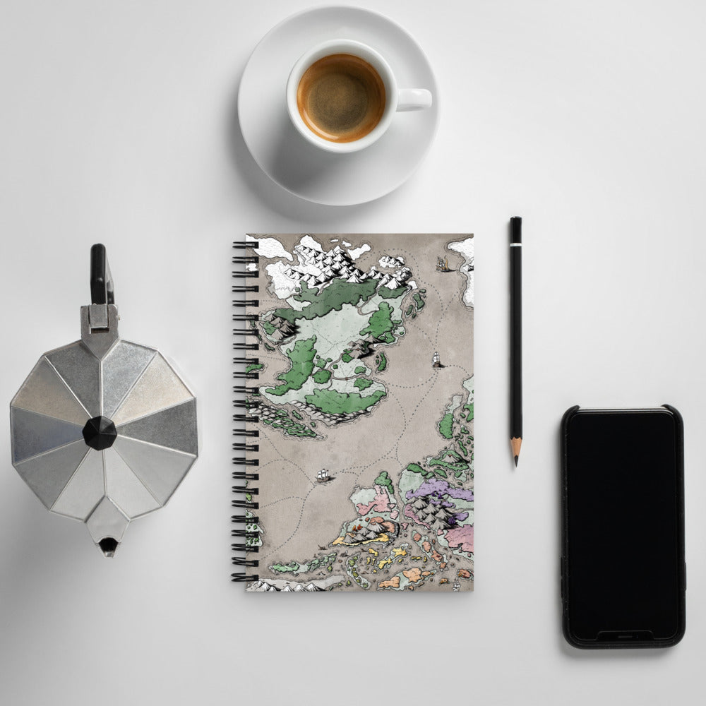 The Ortheiad map is shown on the front of a spiral notebook, surrounded by kettle, cup and saucer, pencil, and a phone for scale.