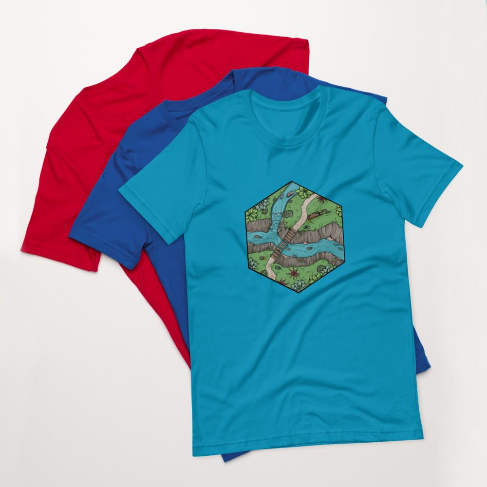 An aqua version of the Perilous Crossing shirt sits on top of the royal blue and bright red versions.
