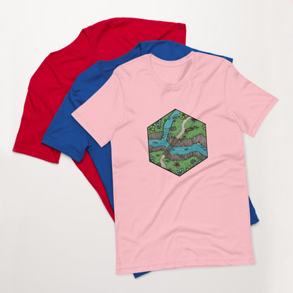 A pink version of the Perilous Crossing shirt sits on top of the royal blue and bright red shirts.